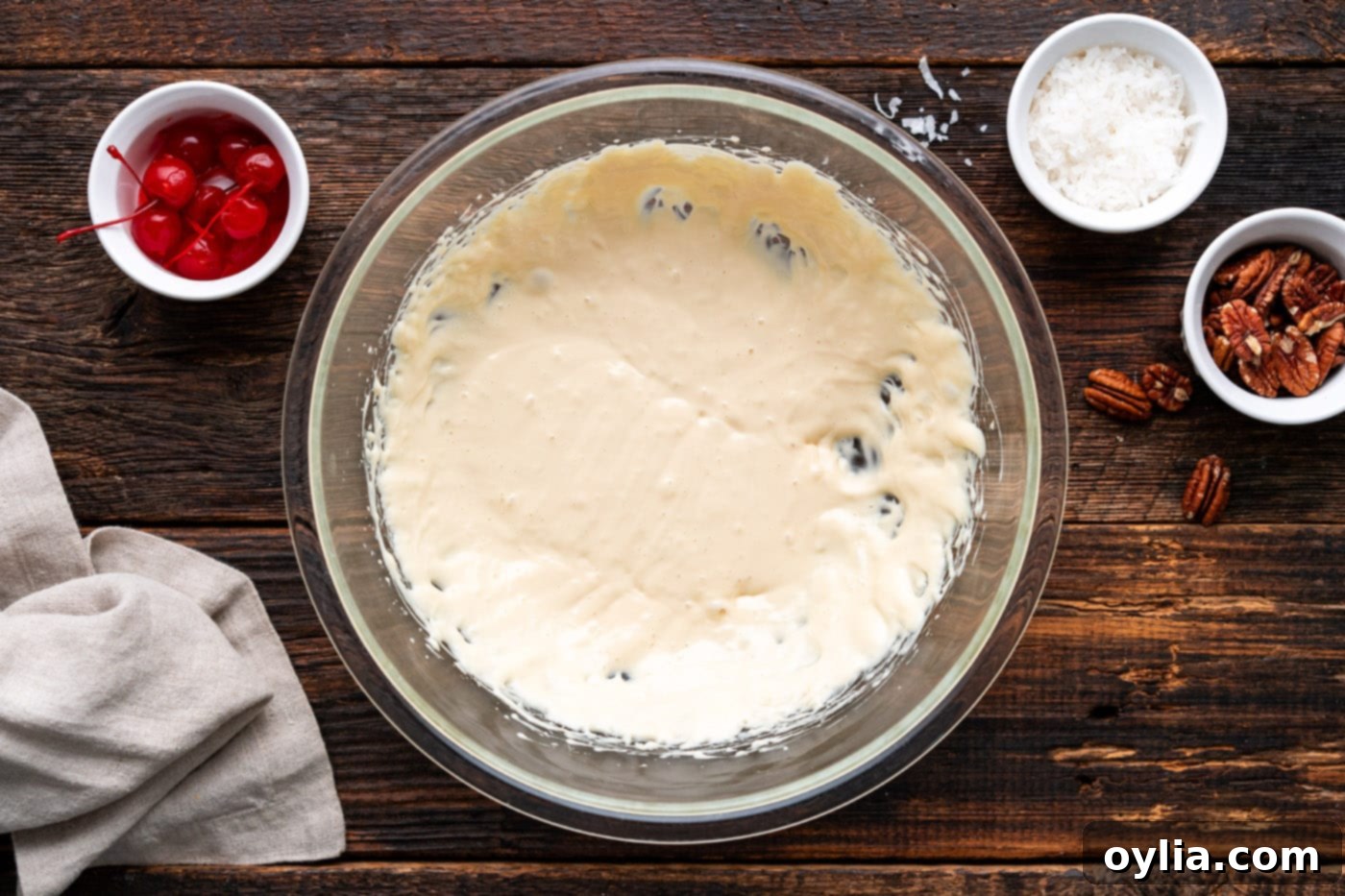 Lemon juice and sweetened condensed milk mixture being beaten until light and fluffy in a large bowl.