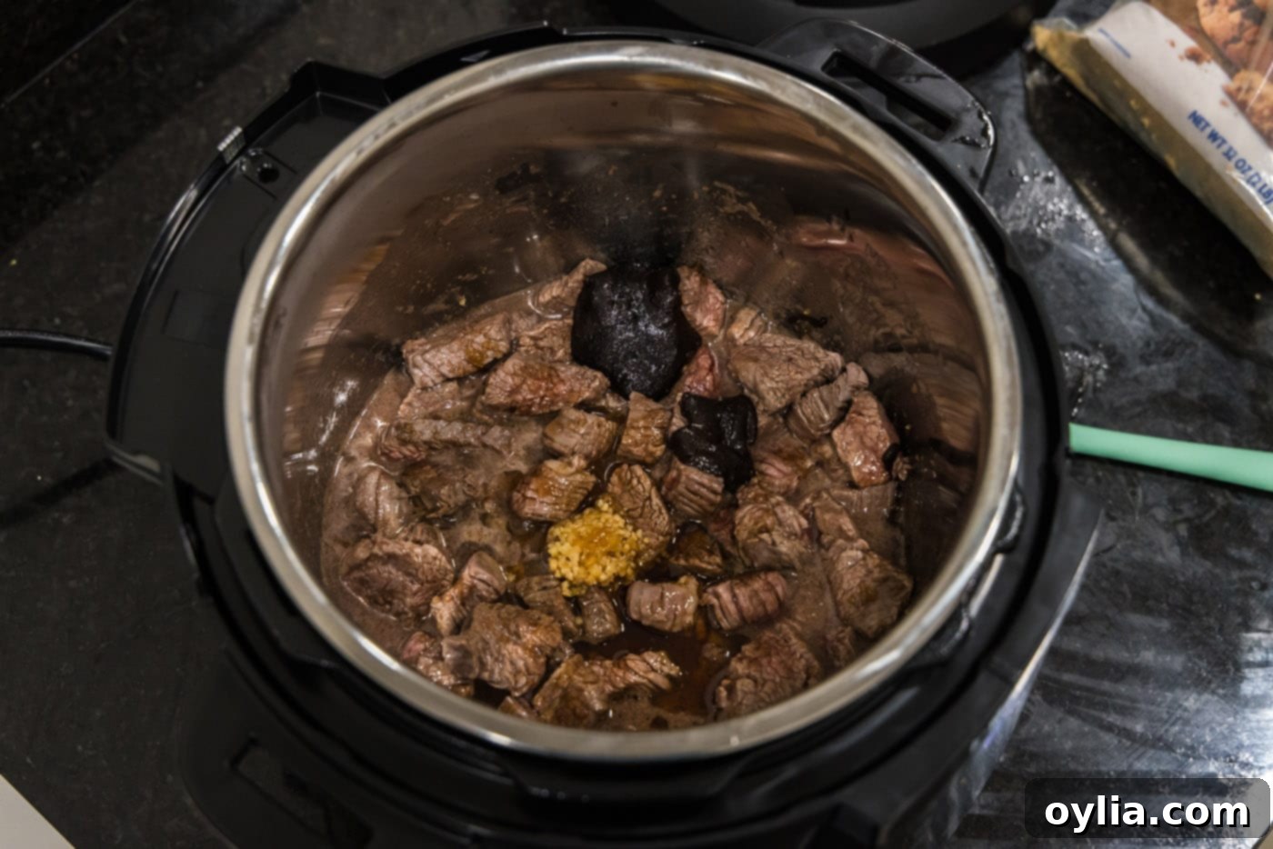 Sautéed flank steak cubes mixed with garlic, brown sugar, liquid smoke, soy sauce, and beef base in the Instant Pot.