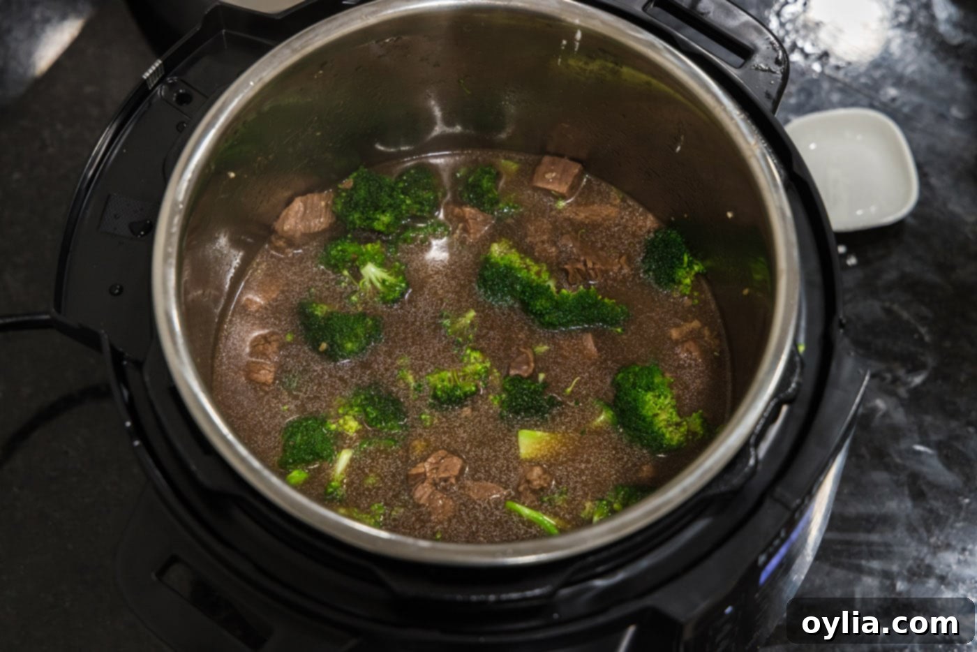 The beef and broccoli mixture simmering and thickening in the pressure cooker.