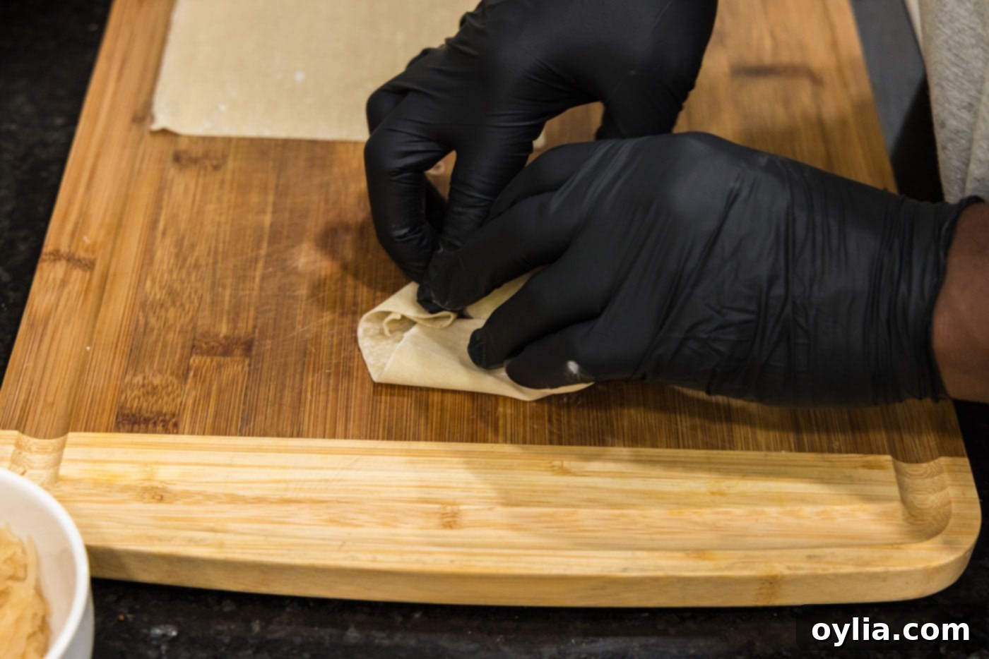 demonstrating how to fold an egg roll wrapper