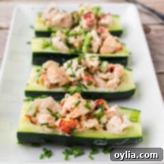 Four Lobster Cucumber Boats on a white serving platter topped with chives