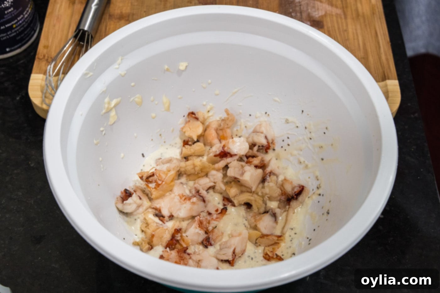 chopped lobster meat added to bowl of dressing