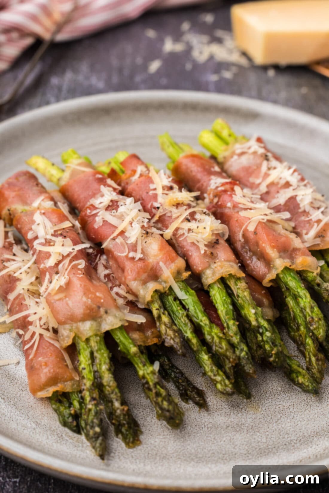 Prosciutto Wrapped Asparagus stacked on a plate, ready to be served