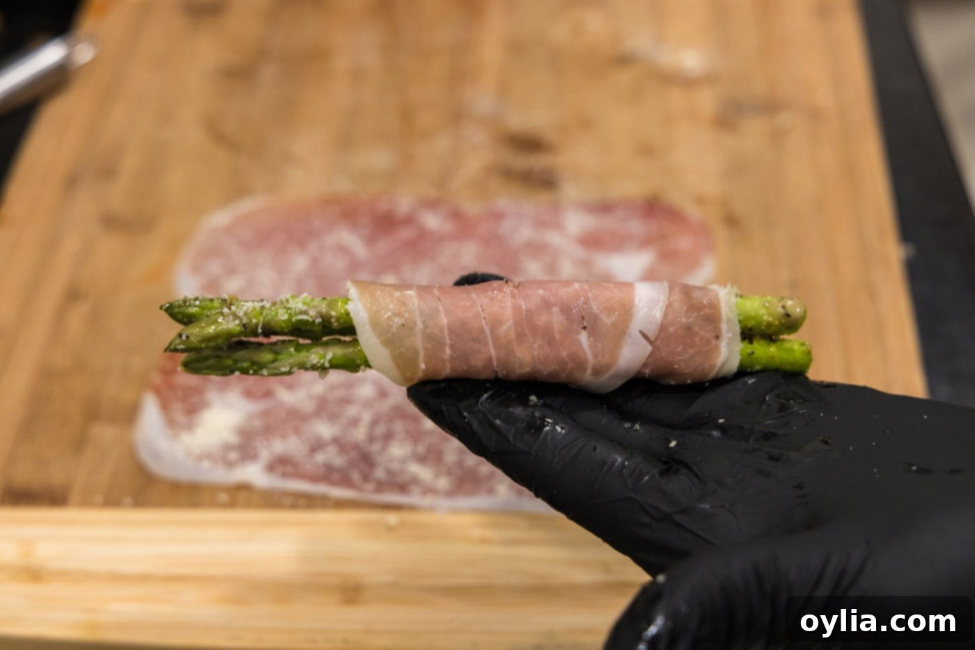 Individual prosciutto wrapped asparagus spears, ready for baking