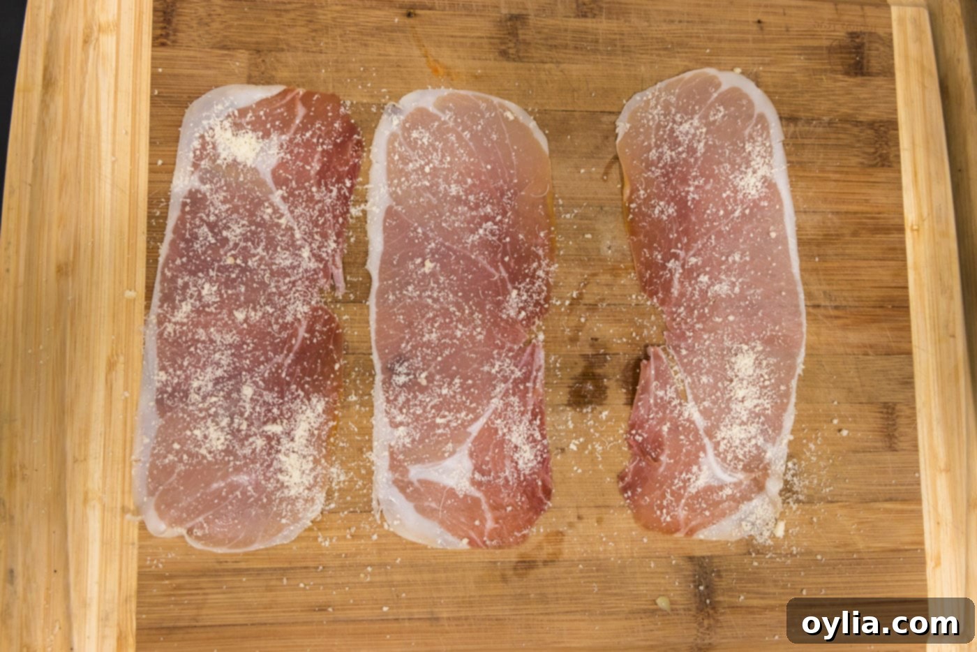 Thin slices of prosciutto with grated Parmesan cheese sprinkled on top
