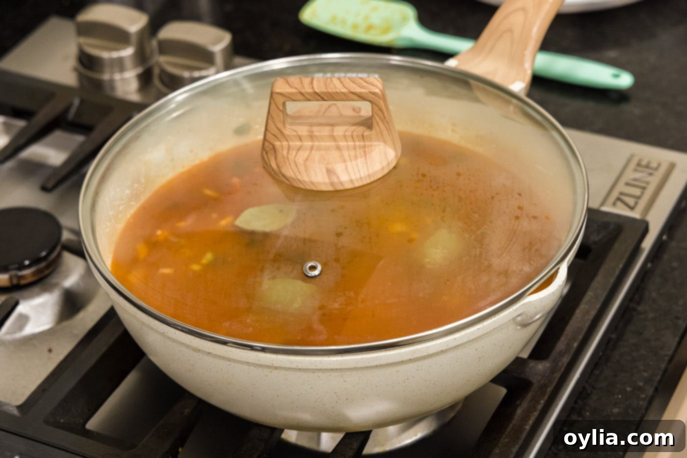 simmering red bean mixture in skillet with a lid
