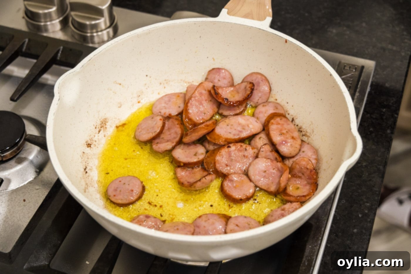 cooking andouille sausage in a skillet with oil