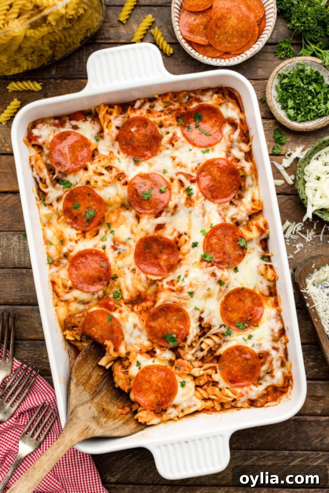 Hearty Sausage and Pepperoni Pizza Bake 2 Serving spoon resting in a Sausage & Pepperoni Pizza Casserole, showcasing melty cheese, spiral pasta, and meat