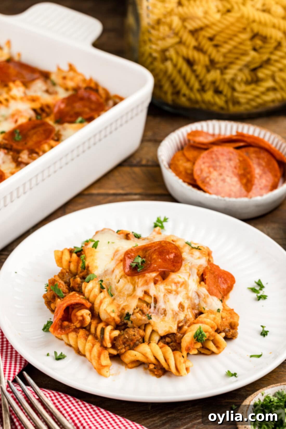 Hearty Sausage and Pepperoni Pizza Bake 11 Serving of Sausage & Pepperoni Pizza Casserole on a white plate, garnished with fresh basil leaves