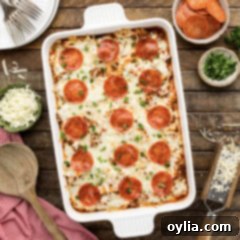 Hearty Sausage and Pepperoni Pizza Bake 12 Close up photo of a casserole dish of Sausage & Pepperoni Pizza Casserole, with golden cheese and pepperoni on top