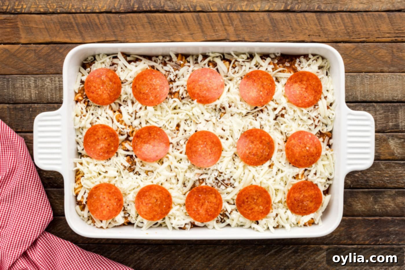 pepperoni slices arranged on top of pizza casserole over a layer of mozzarella cheese