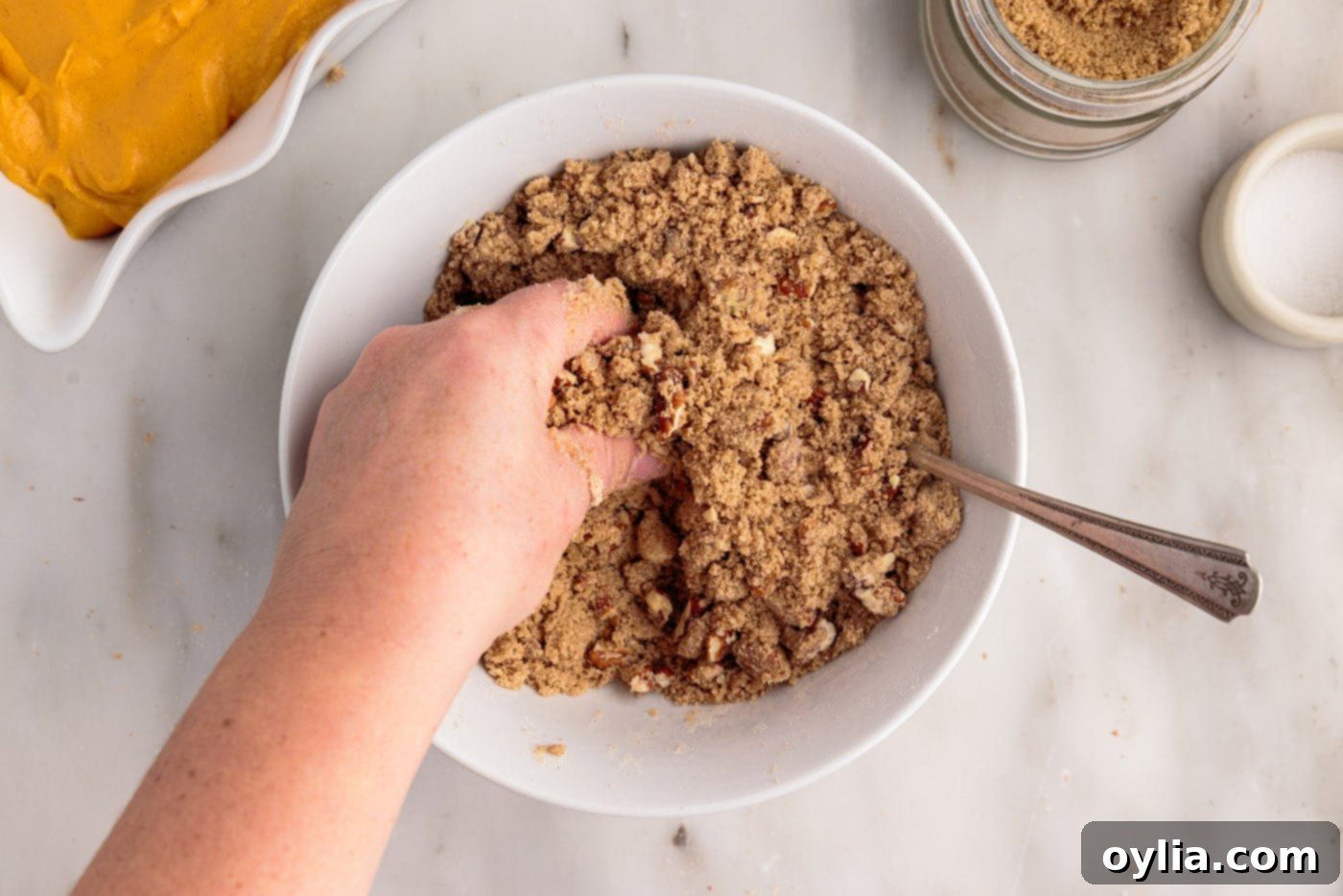 crumbling butter into pecan streusel topping mixture with hands