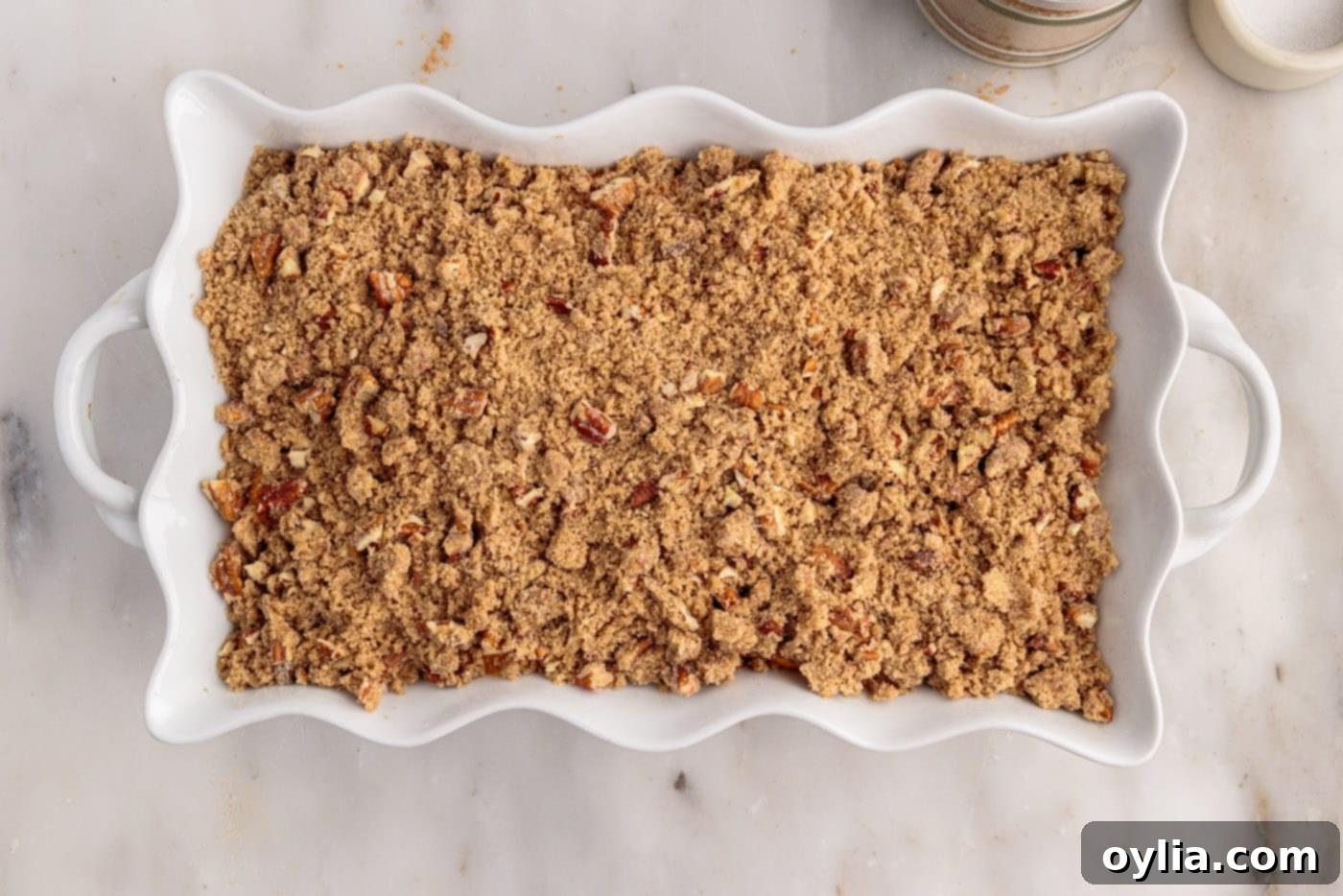 sweet potato souffle in baking dish with pecan streusel topping sprinkled on top
