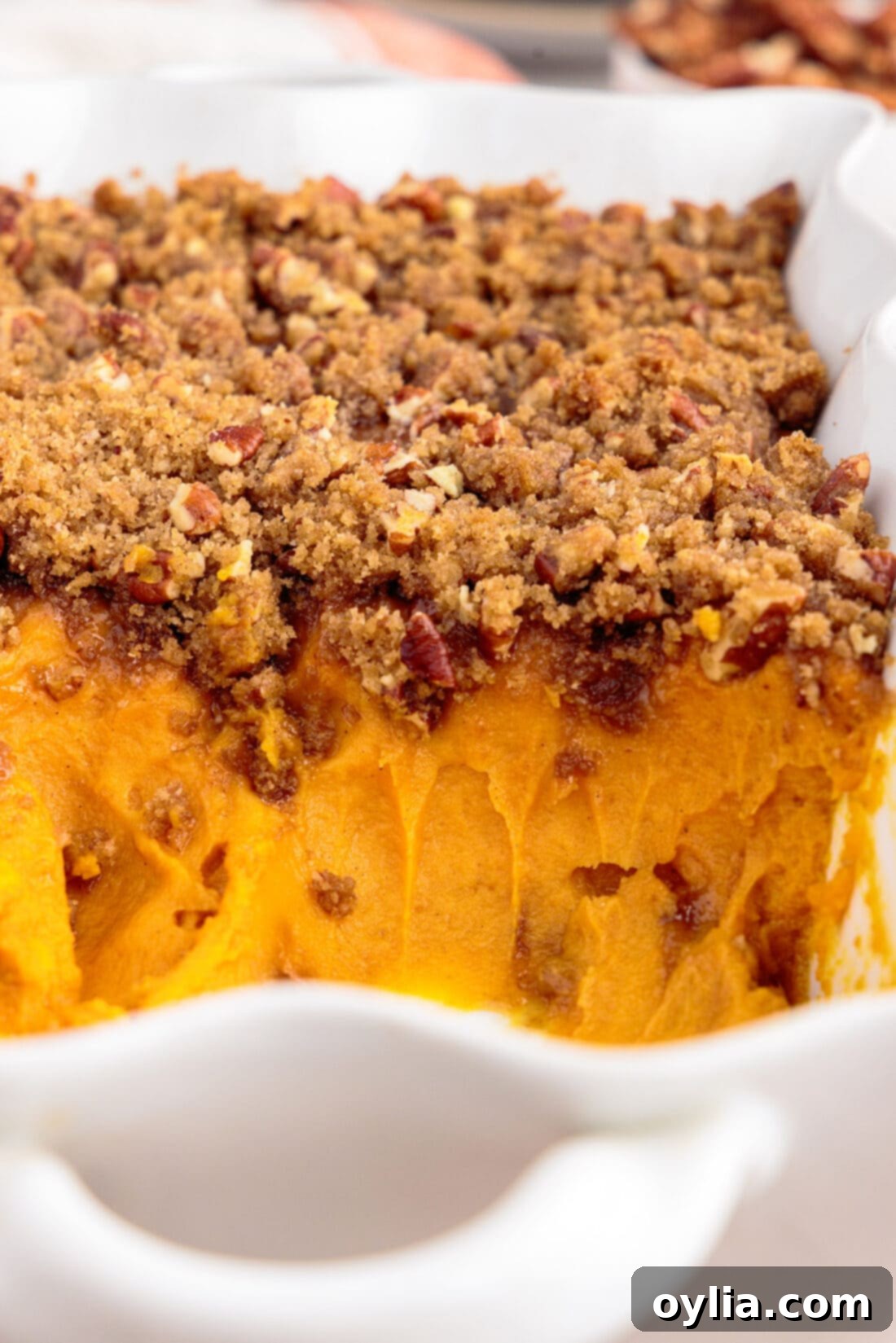 Sweet Potato Souffle in a baking dish with several servings already scooped out, revealing the creamy interior.