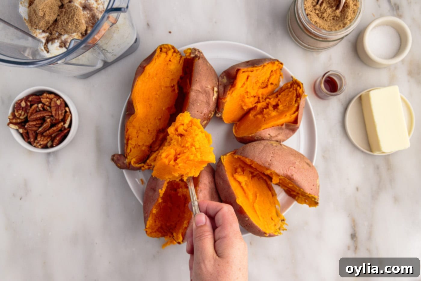 scooping sweet potatoes from the skin after baking