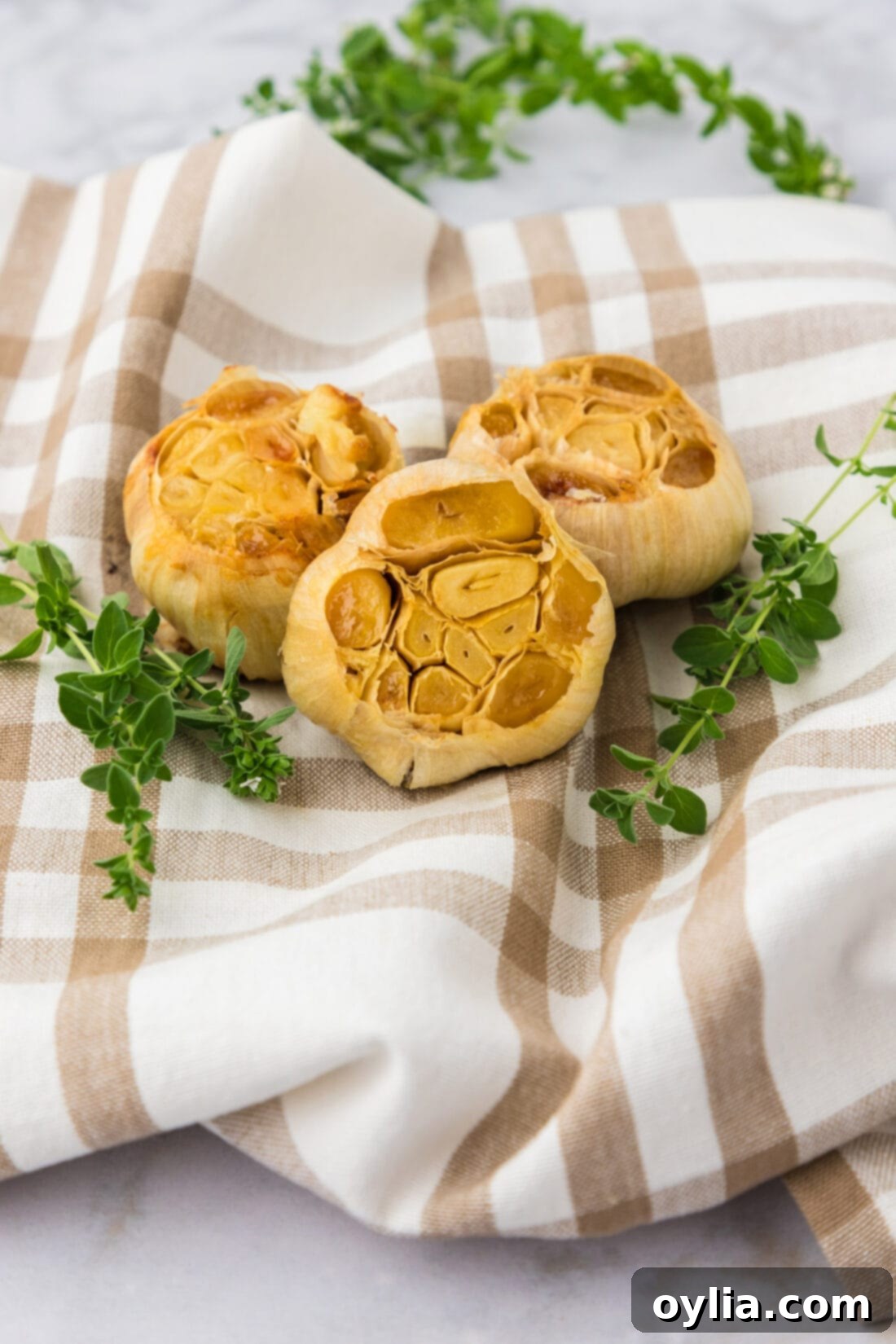 Three bulbs of roasted garlic on a towel