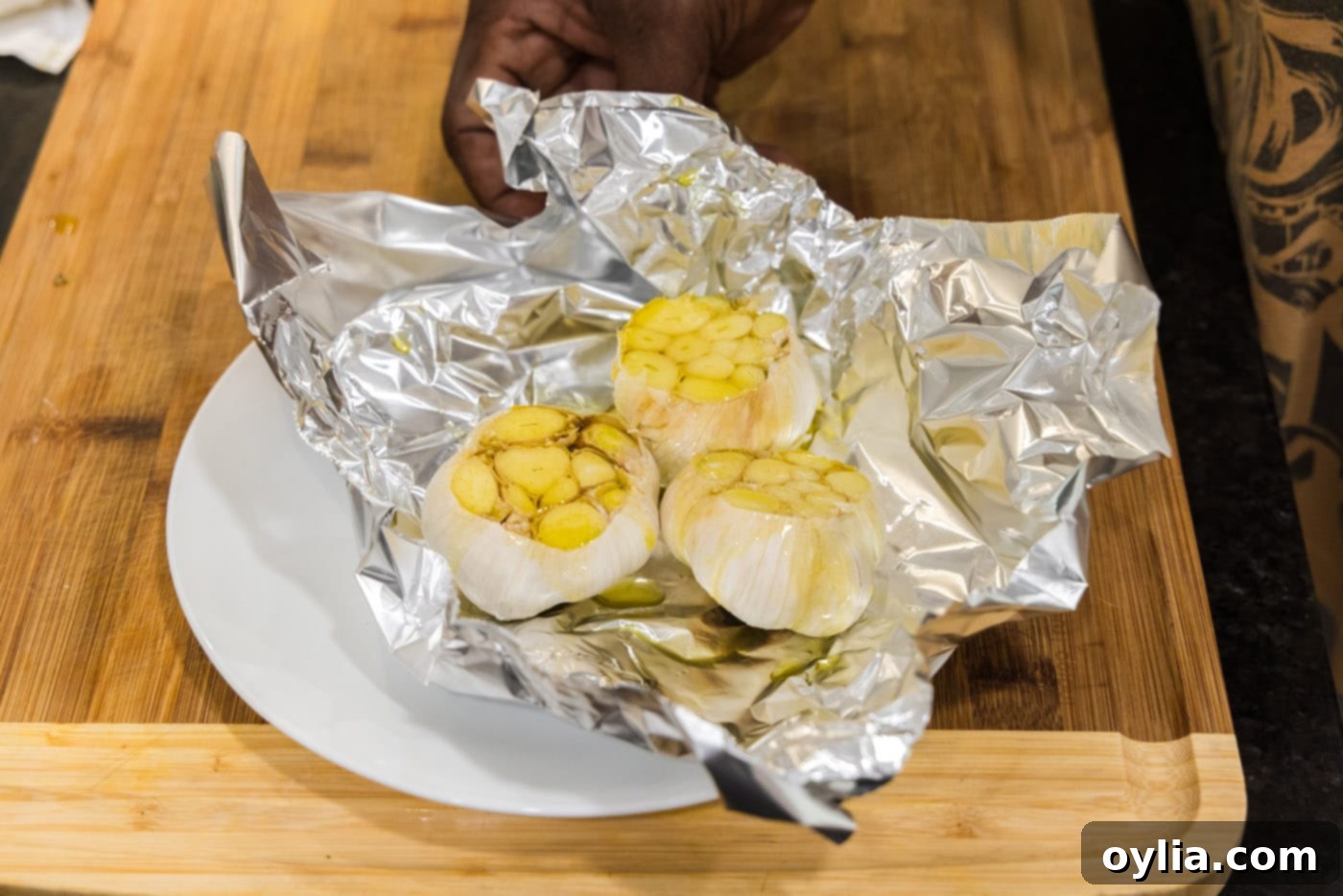 garlic bulbs in aluminum foil with olive oil