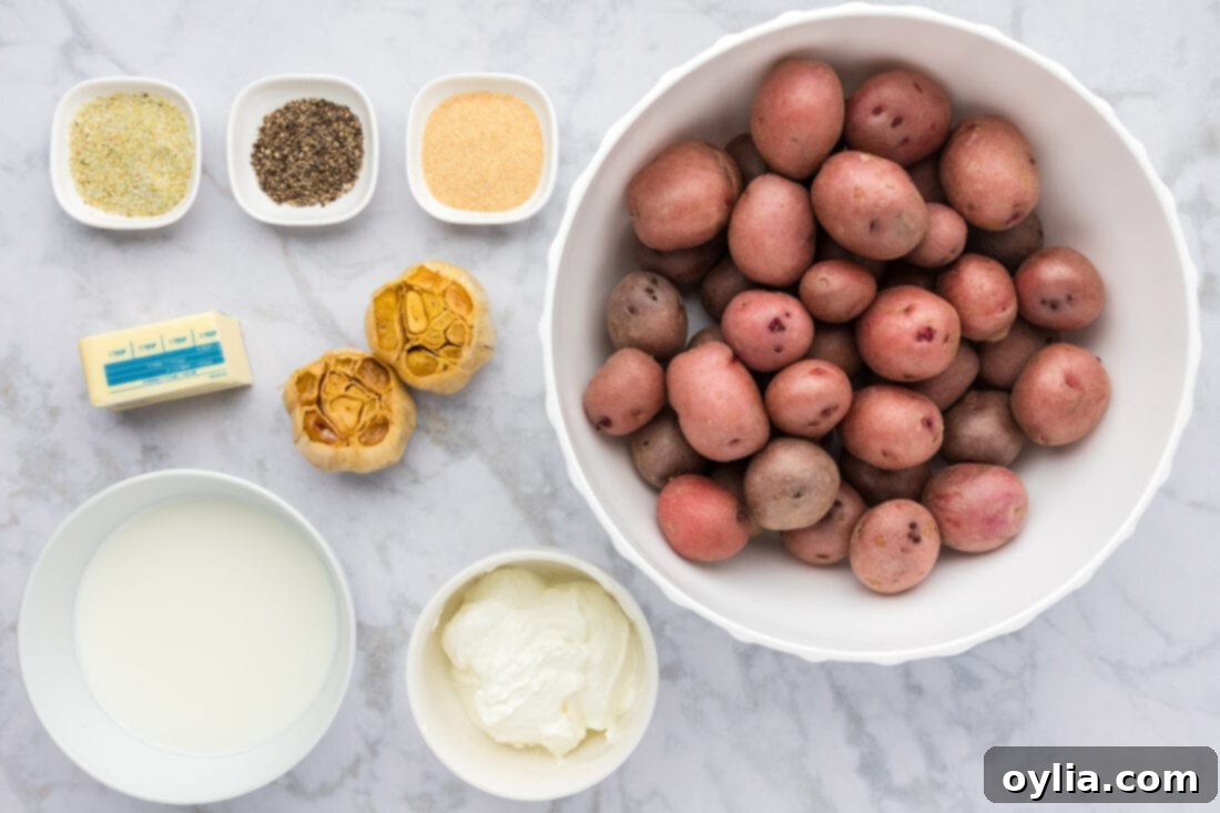 Ingredients for Garlic Mashed Potatoes laid out on a kitchen counter, including potatoes, garlic, butter, and cream.