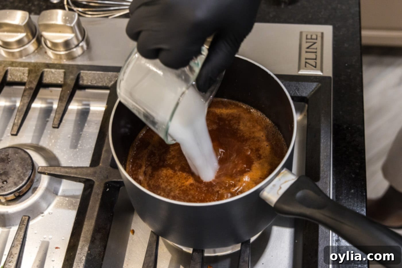 pouring a cornstarch slurry into barbecue sauce to thicken it