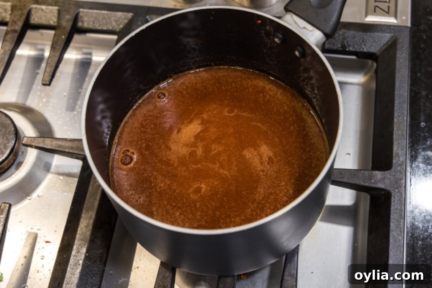 Dr. Pepper barbecue sauce simmering and thickening in a saucepan
