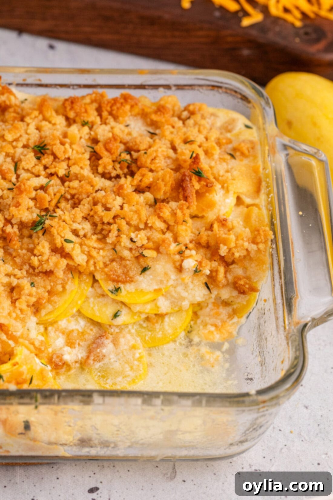 Close up photo of Squash Casserole with a serving removed, showcasing the creamy interior and golden-brown cracker topping