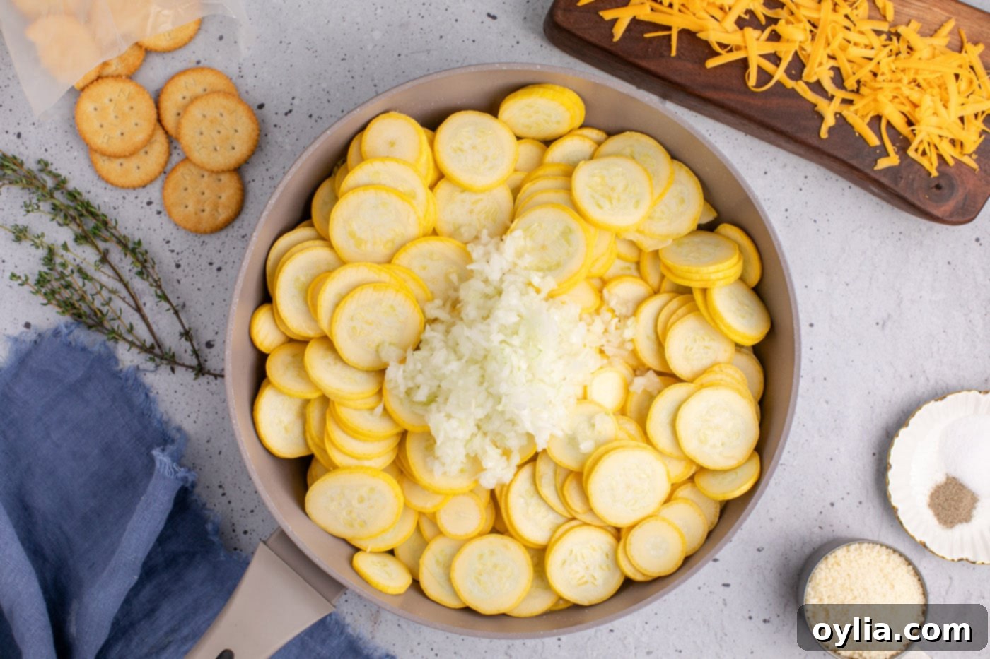 squash slices with chopped onion in a skillet, beginning to soften