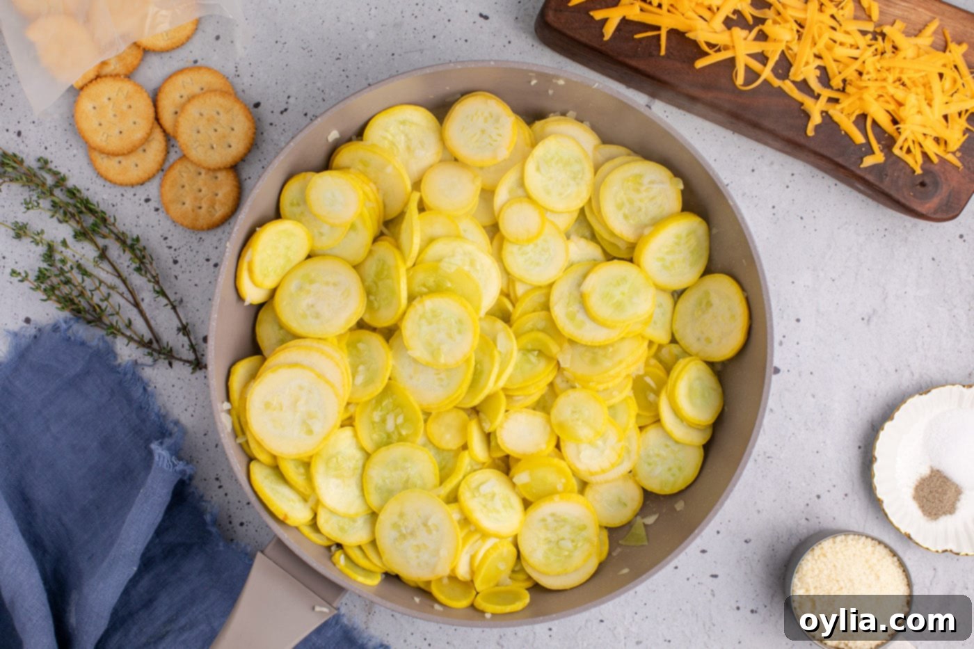 partially cooked squash slices and onion in a skillet, showing reduced water