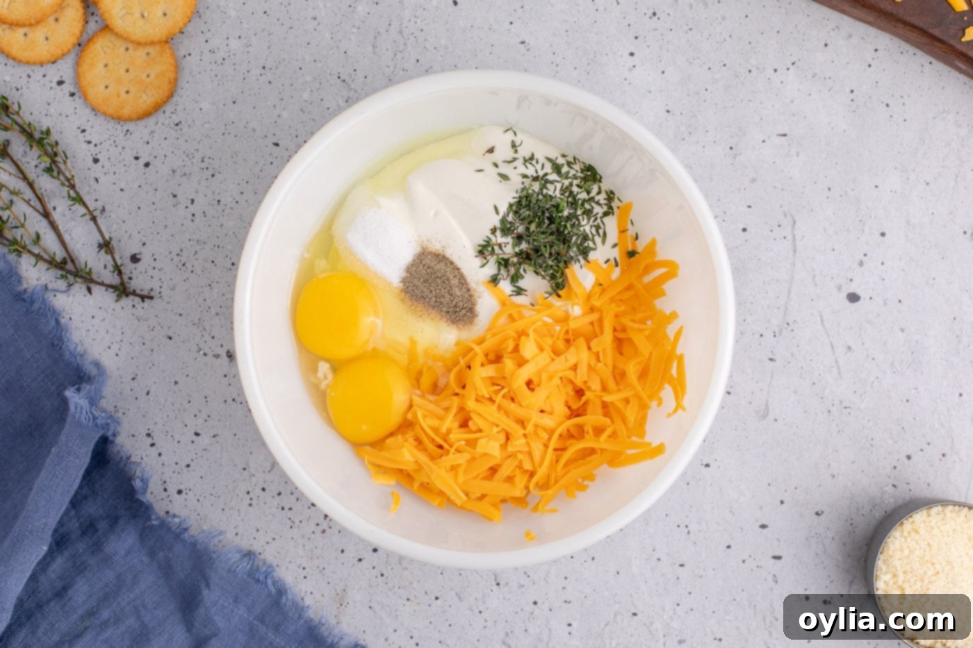 ingredients for yellow squash casserole in a bowl, showing cheese, sour cream, and seasonings