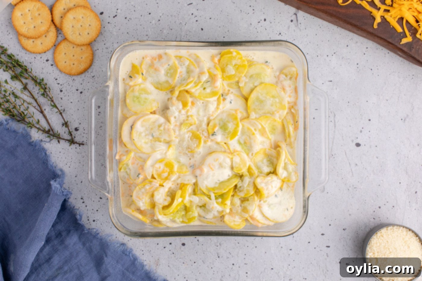 yellow squash with filling evenly spread in a glass baking dish