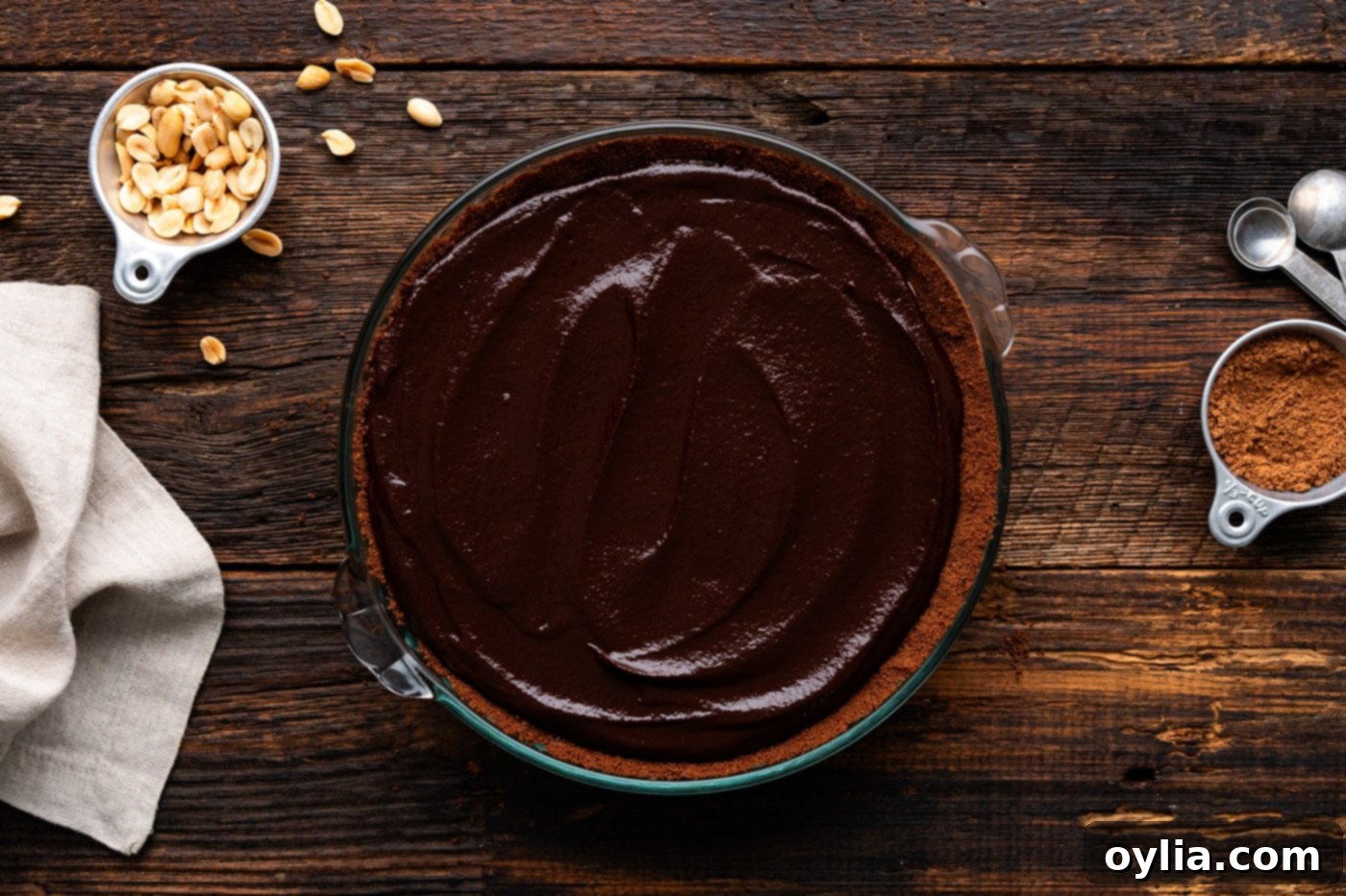 The finished, un-sliced Chocolate Peanut Butter Pie, showcasing its smooth ganache topping and ready for chilling.