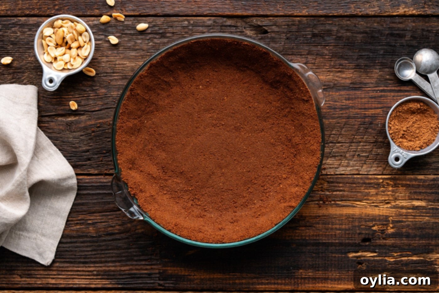 A chocolate graham cracker pie crust expertly pressed into a 9-inch pie plate, showing a smooth and even surface.