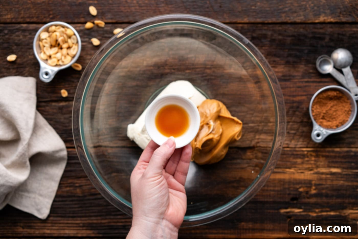 A bowl containing cream cheese, peanut butter, and vanilla extract, ready to be mixed for the pie filling.