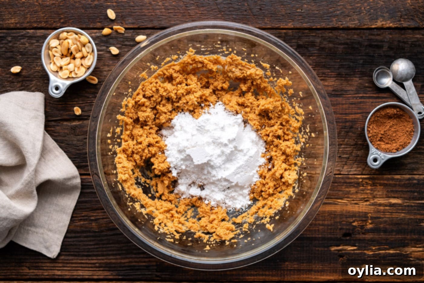 Powdered sugar being added to the creamy peanut butter and cream cheese mixture, ready for the next stage of blending.