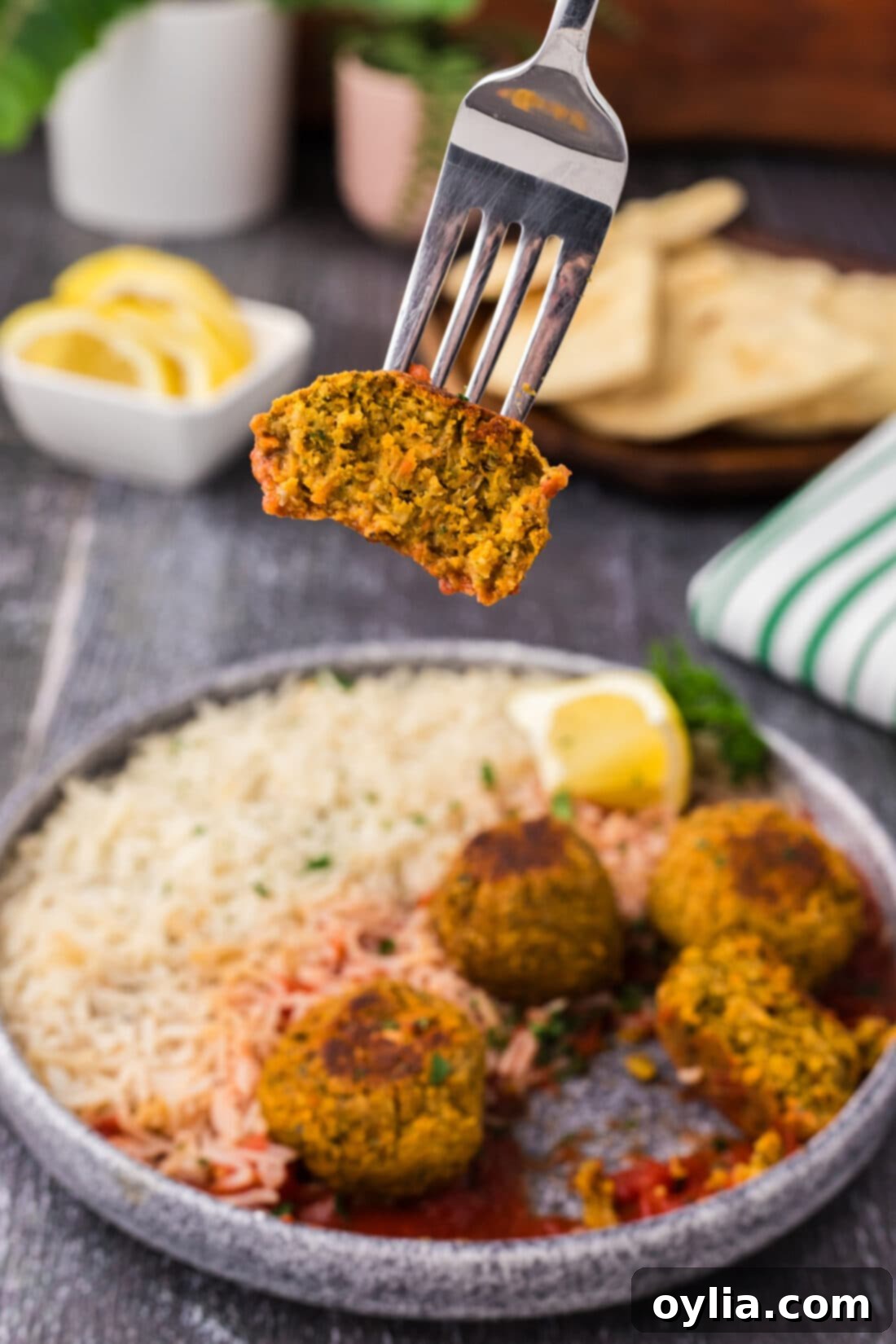 Half of a Lentil Meatball is lifted by a fork, showing its internal texture.