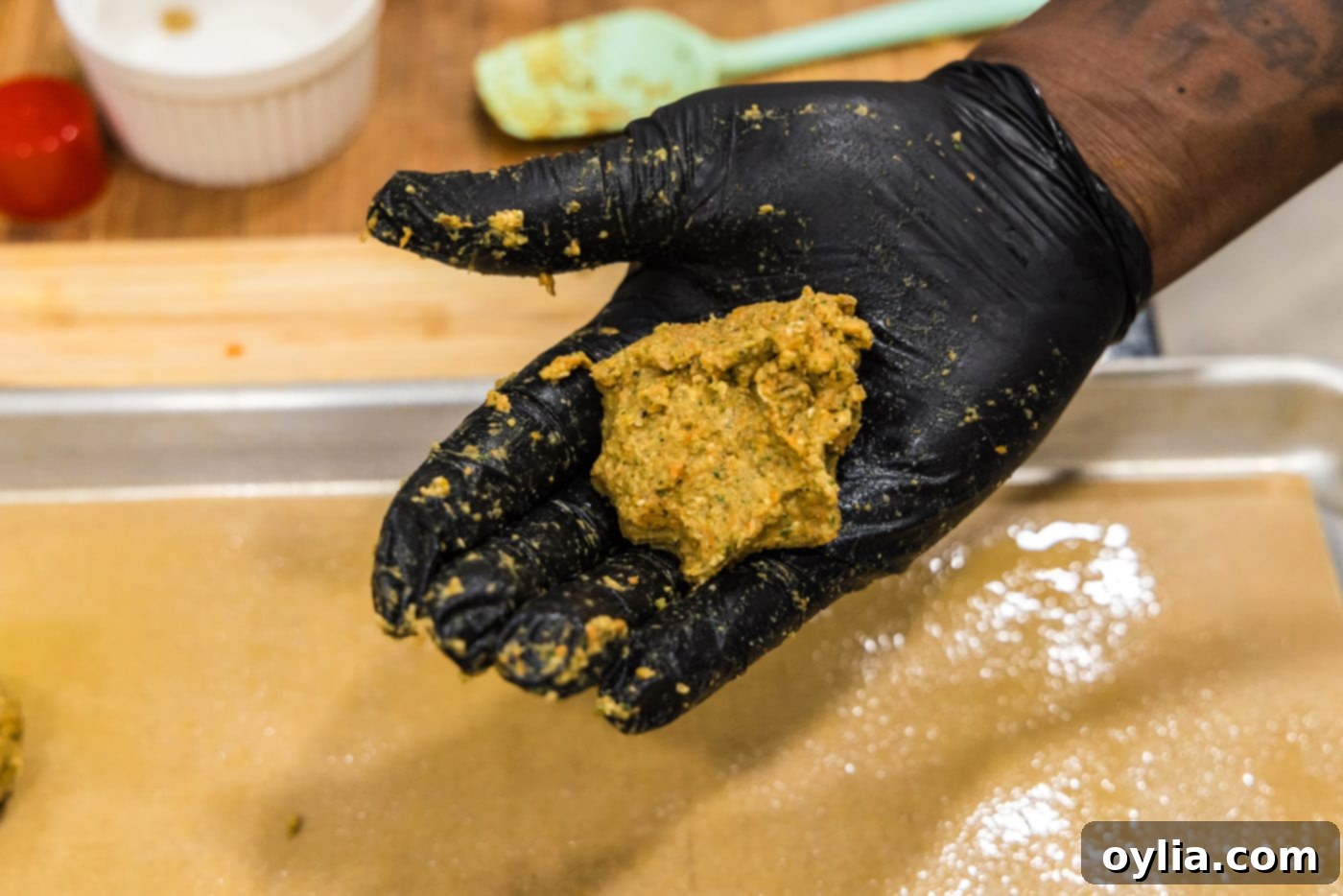 A portion of the lentil meatball mixture resting in the palm of a hand, ready to be rolled.