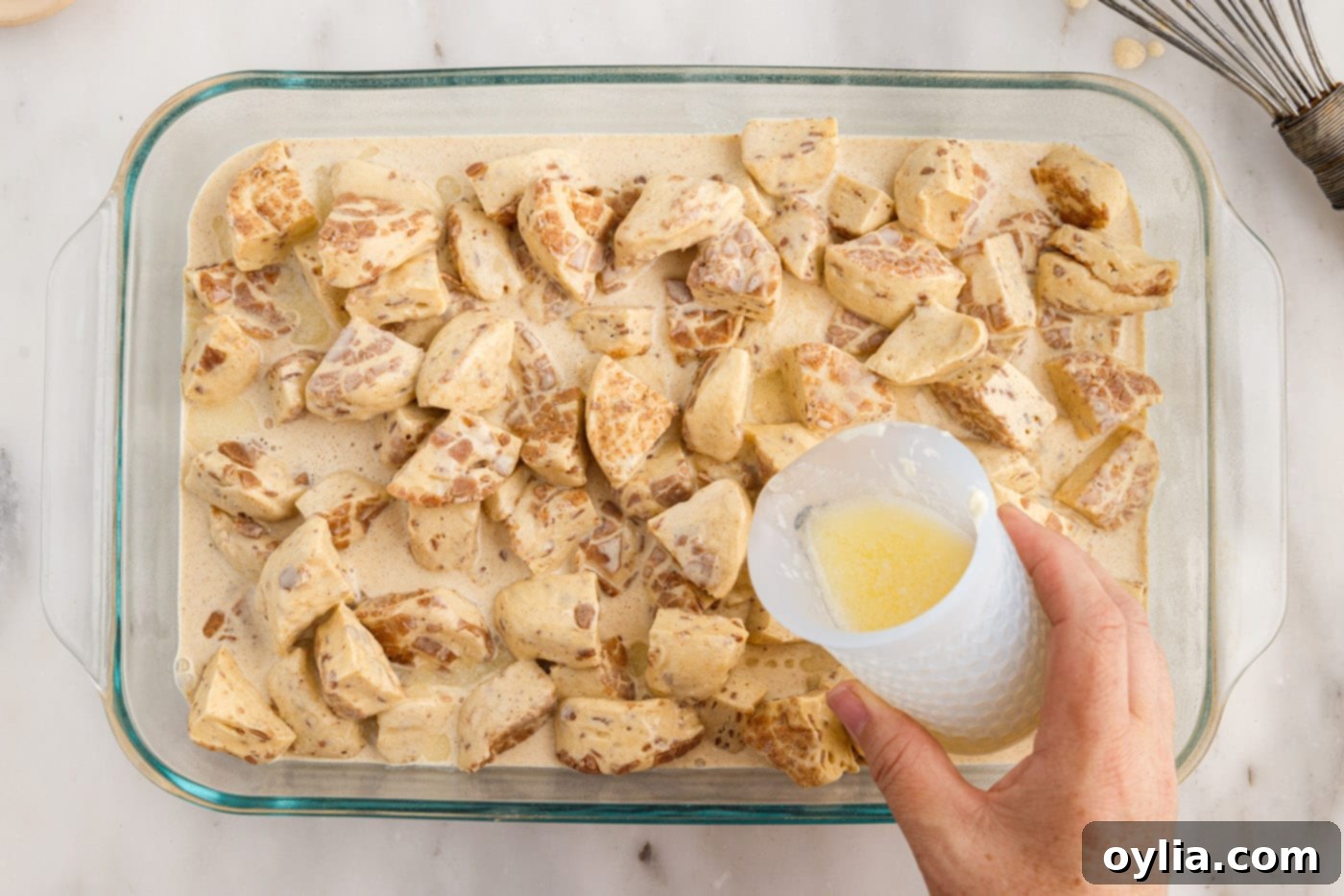 pouring melted butter over cinnamon roll ingredients