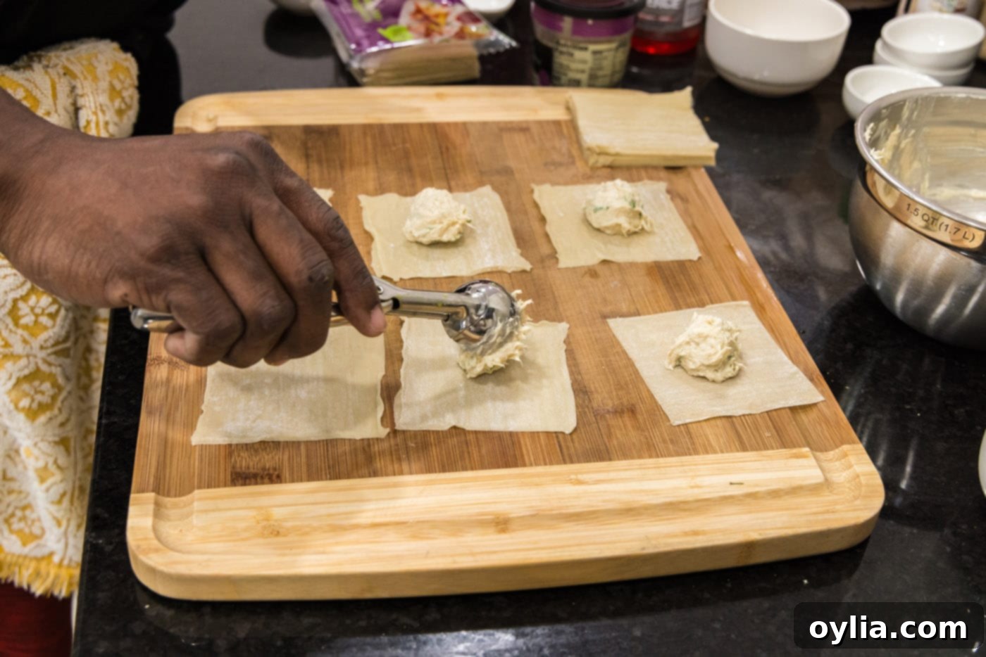scooping crab filling into wonton wrappers