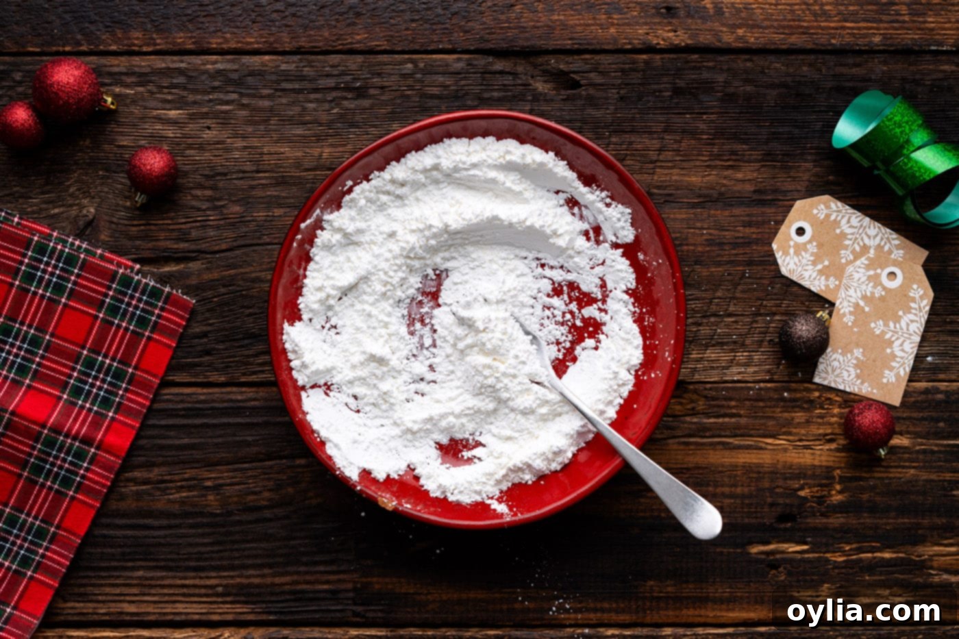 Mixing together cornstarch and powdered sugar on a plate, creating the perfect coating for the Grinch cookies.