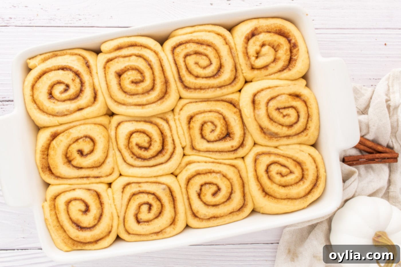 Pumpkin cinnamon roll dough after its second rise, filling the baking pan and ready for the oven.