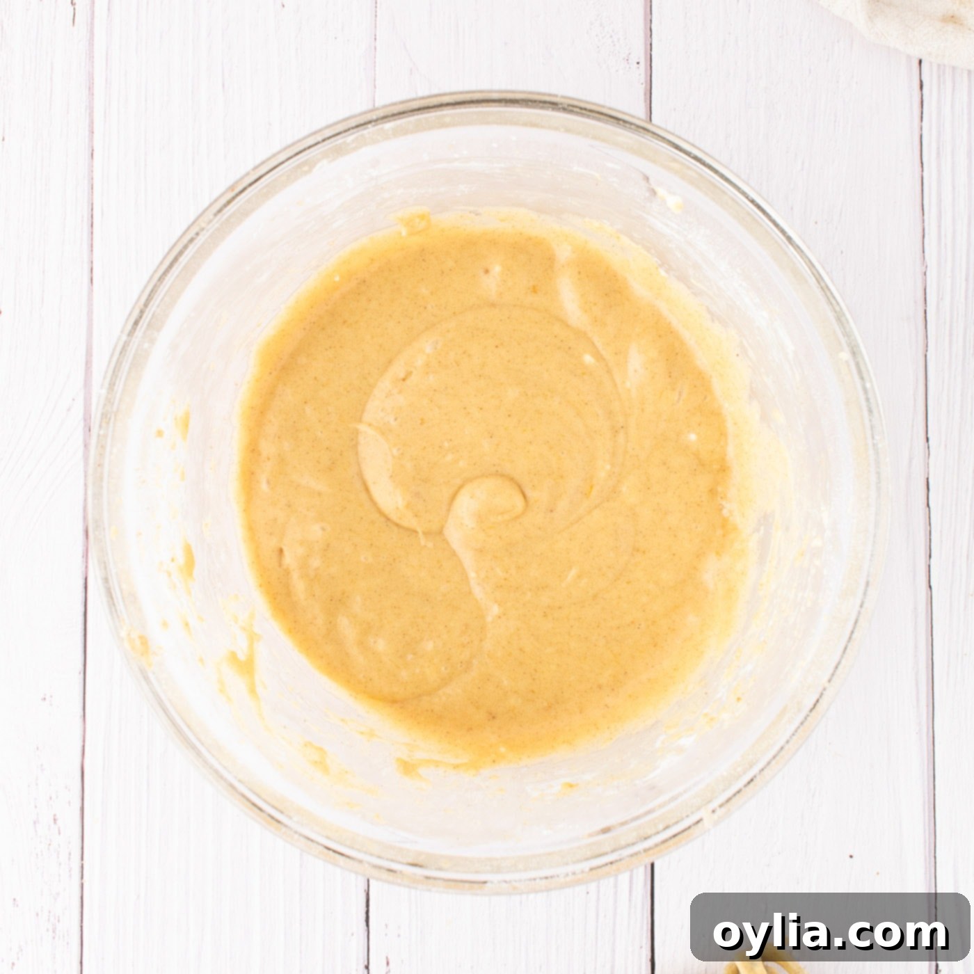 Pumpkin cream cheese frosting in a mixing bowl, smooth and ready to be spread.
