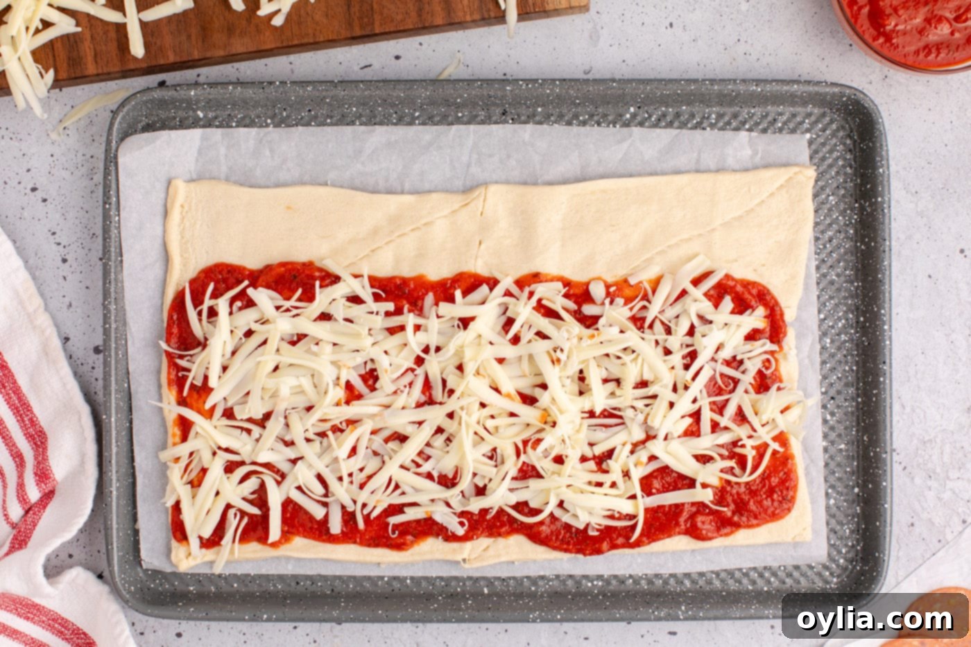 First layer of mozzarella cheese spread over pizza sauce on crescent dough.