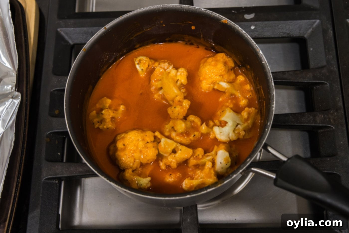tossing cauliflower in buffalo sauce