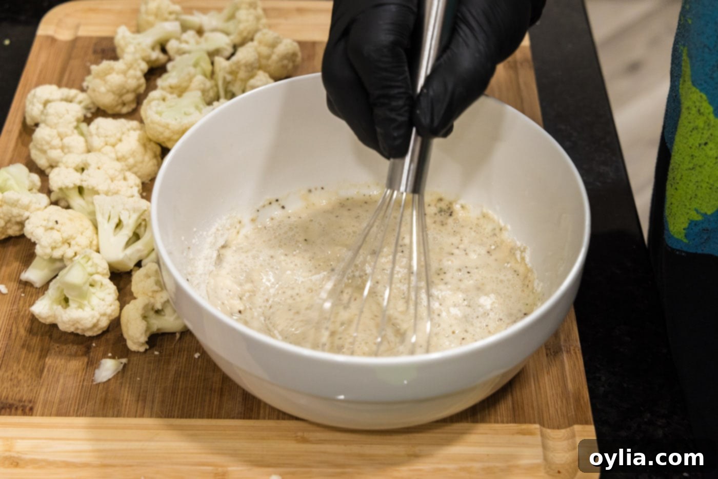 whisking flour, water, and seasoning in a bowl