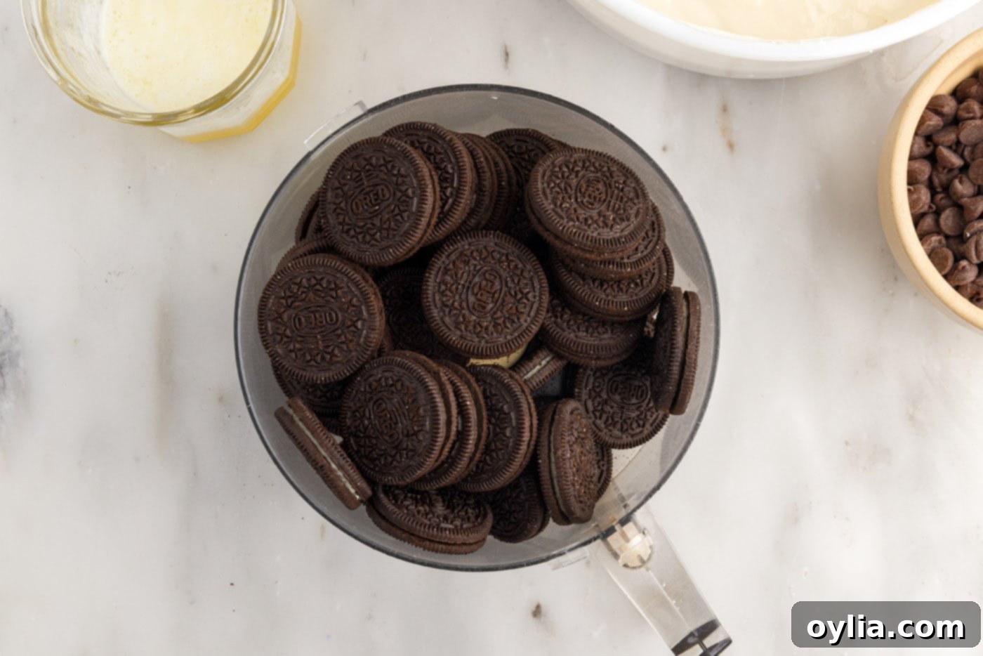 Oreo cookies in a food processor bowl before being pulsed into crumbs.