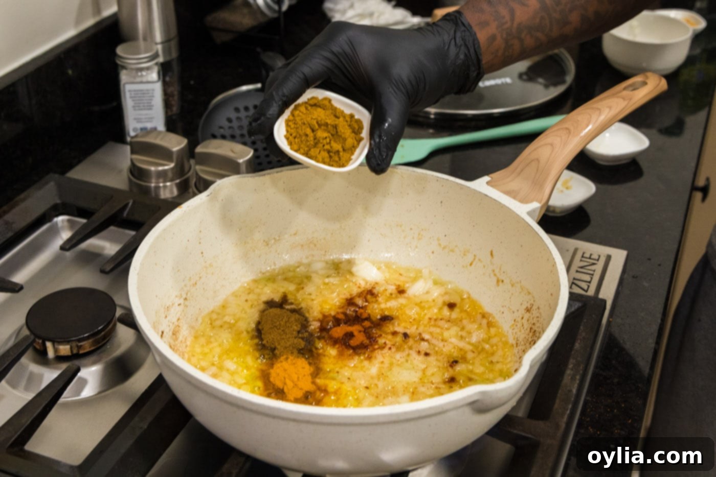 adding spices to curry in a saucepan