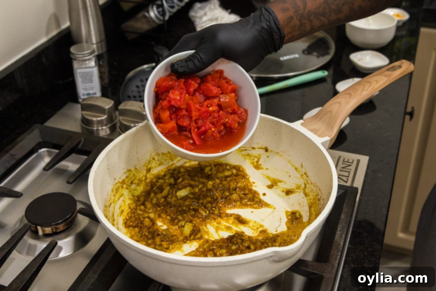 adding diced tomatoes to curry sauce