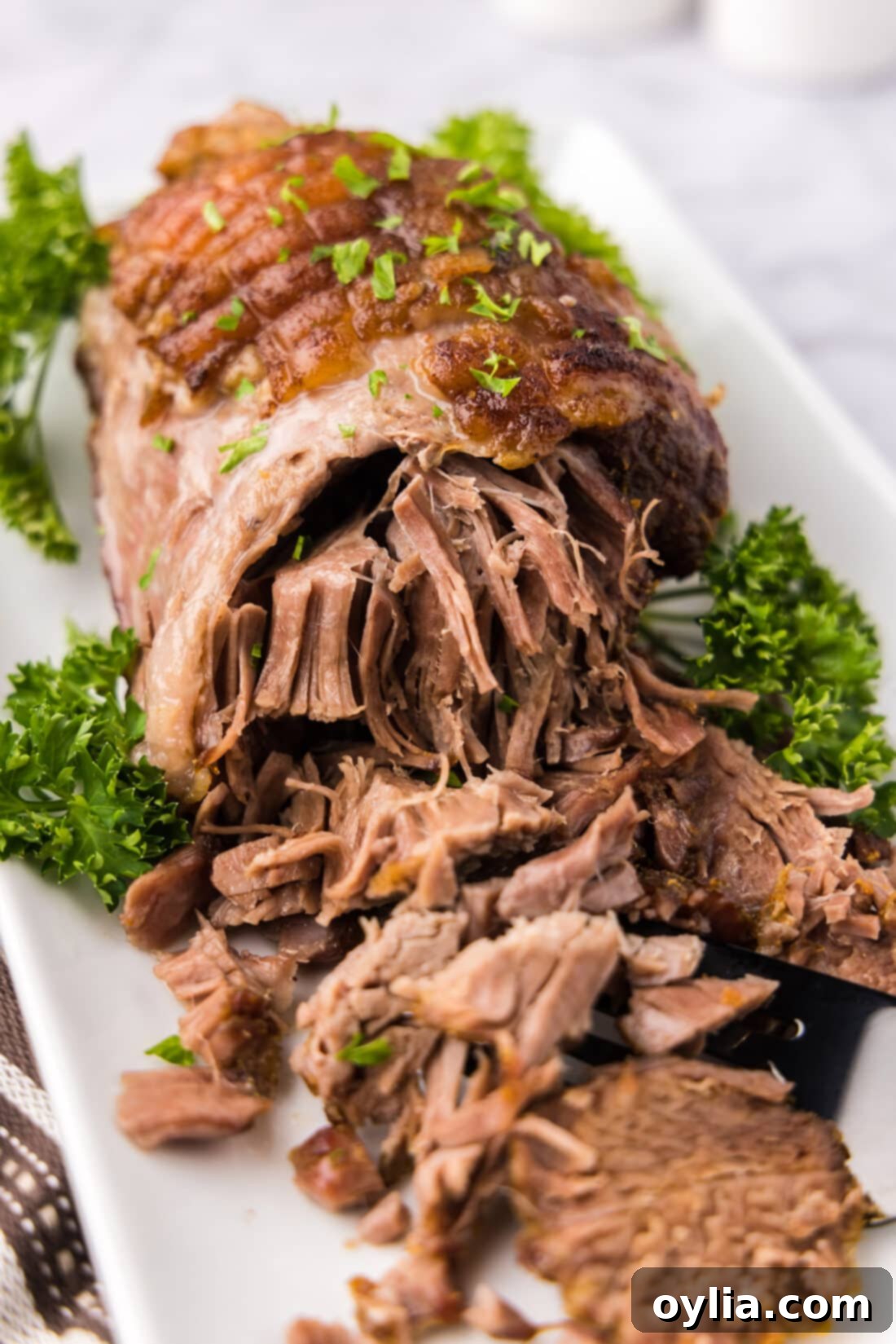 Slow-Roasted Lamb Masterpiece 2 Close up photo of a Leg of Lamb on a platter