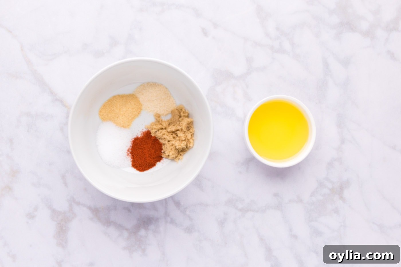seasonings in a bowl next to olive oil