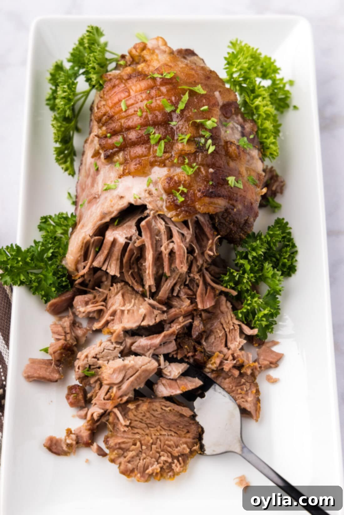 Slow-Roasted Lamb Masterpiece 9 Leg of Lamb on a platter half shredded