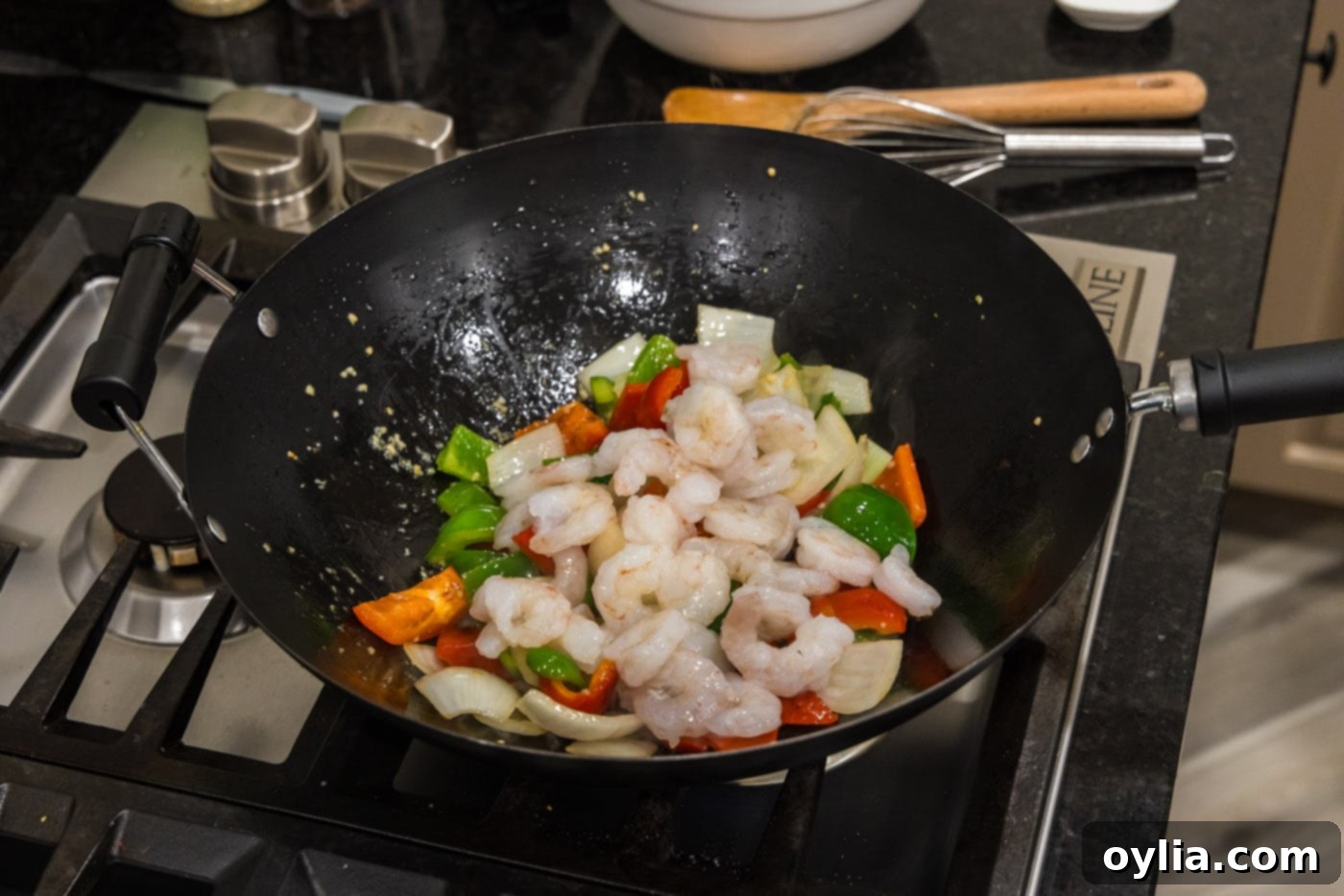 adding shrimp to wok with vegetables